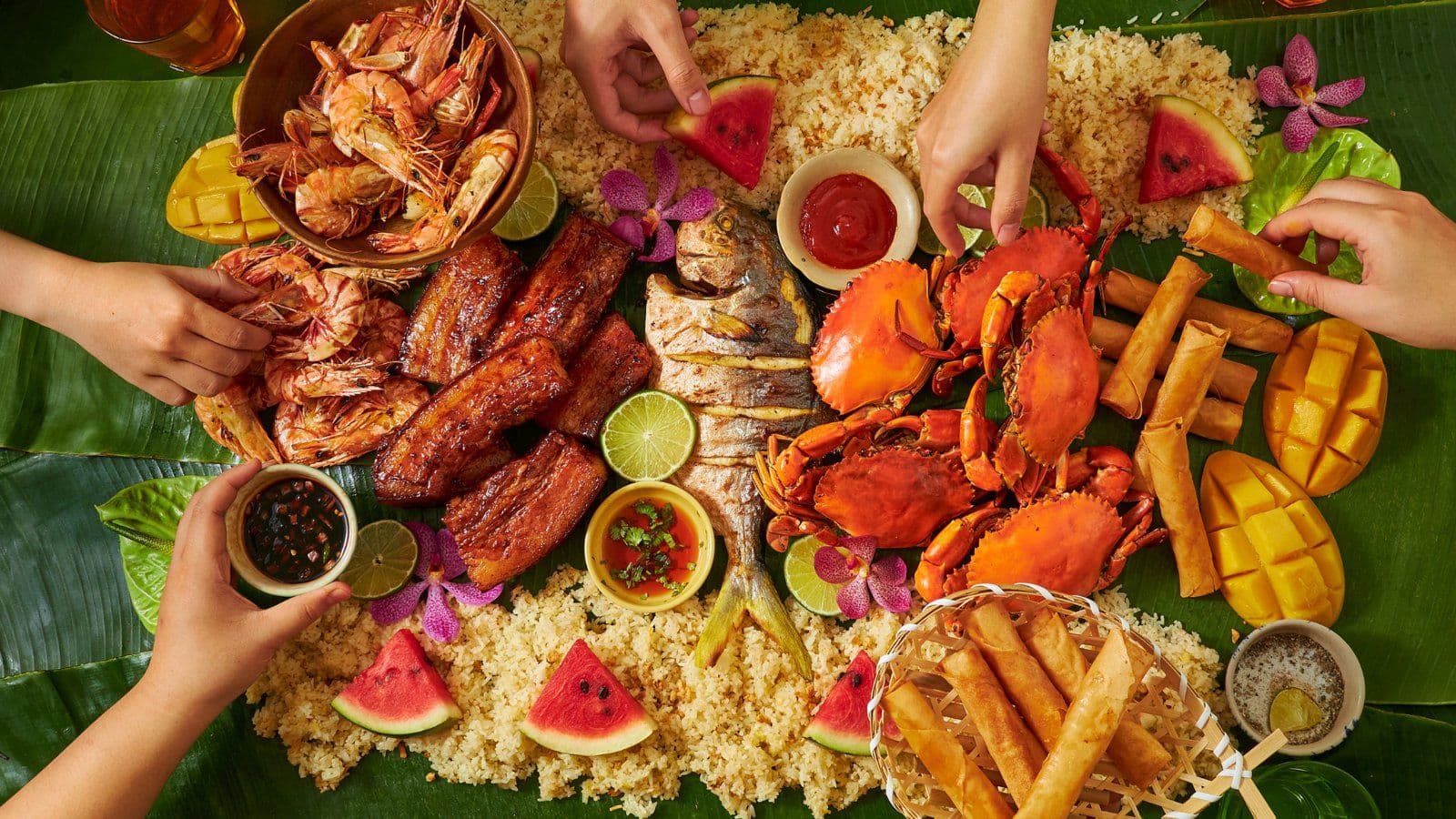 Mains se servant autour d un grand plat de fruits de mer et de riz