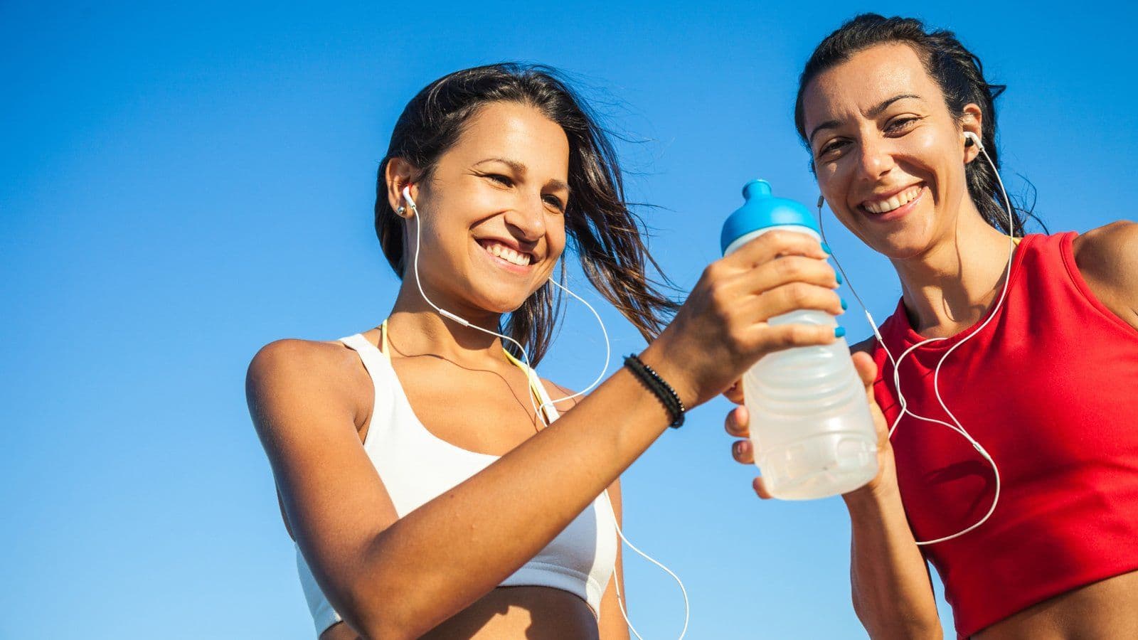Deux sportives partageant une gourde d eau apres l effort