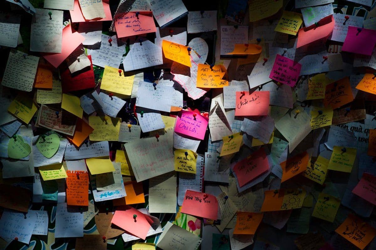 Mur entièrement recouvert de notes et de post-its, métaphore de la surcharge mentale