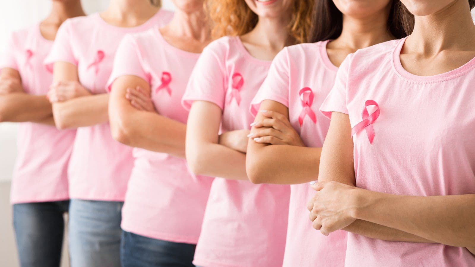 Groupe de femmes en tee-shirt rose portant le ruban de depistage du cancer du sein