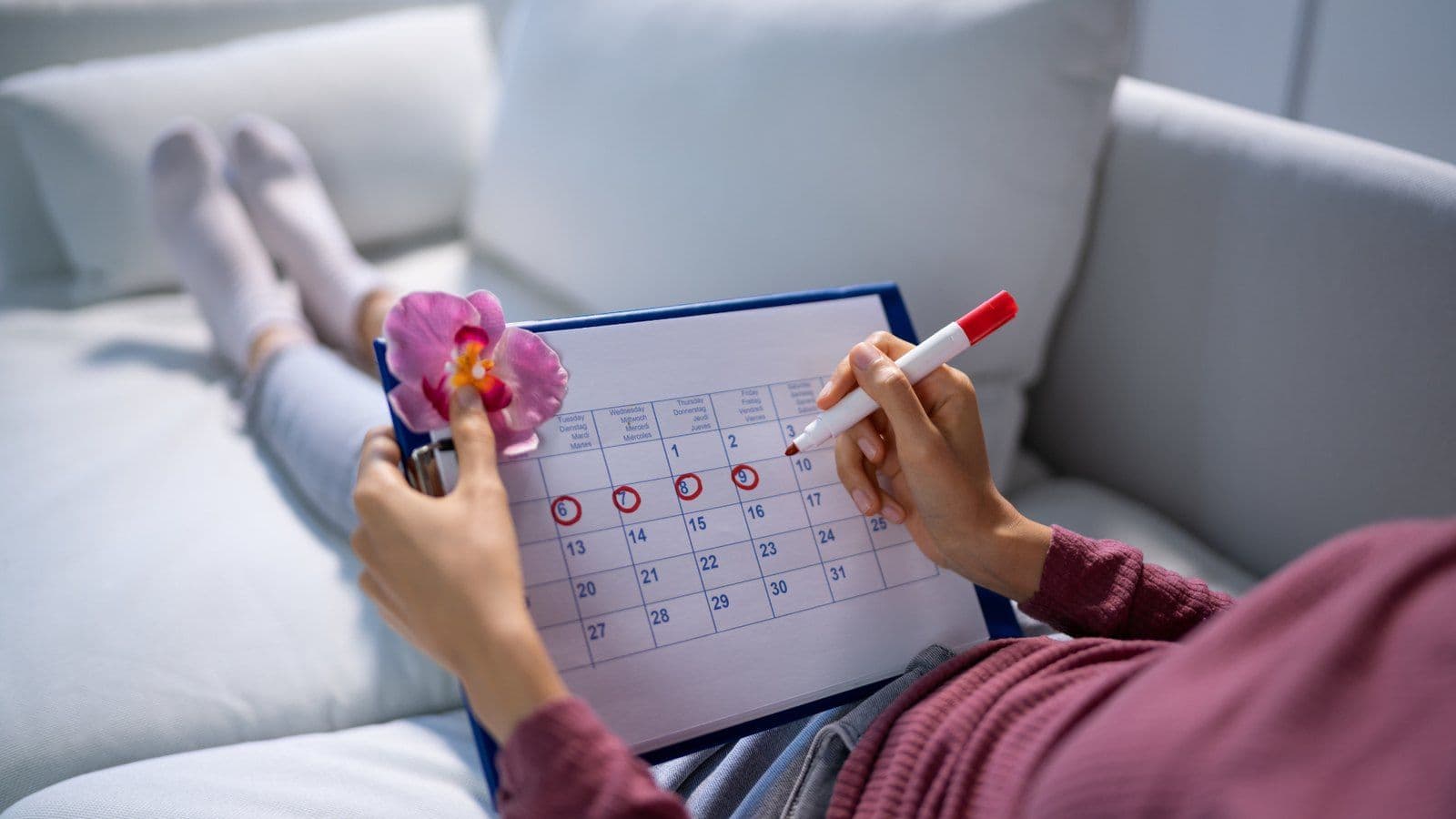 Femme entourant des dates sur un calendrier de suivi de cycle menstruel