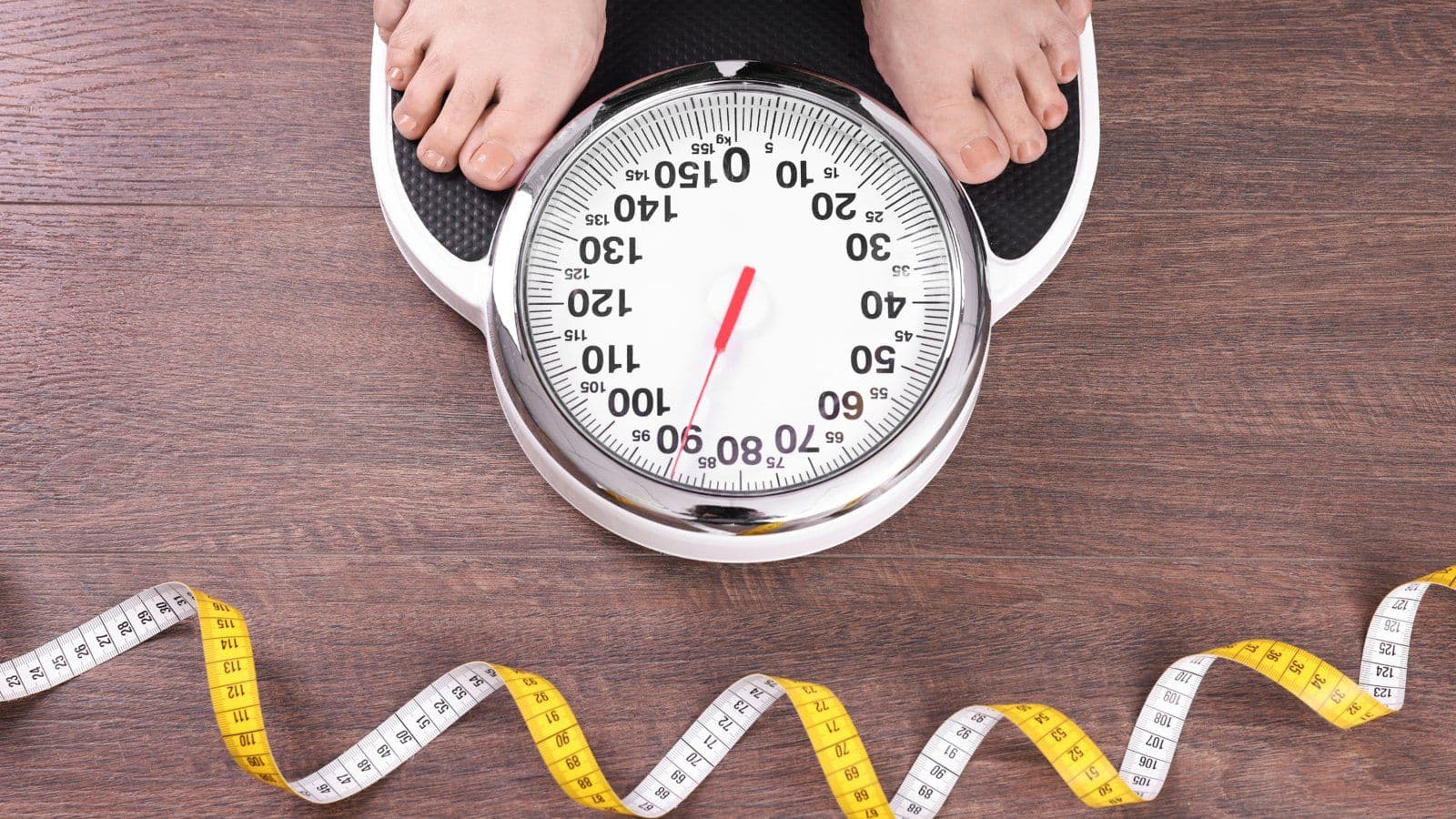 Pieds sur une balance ronde a cote d un metre ruban deroule