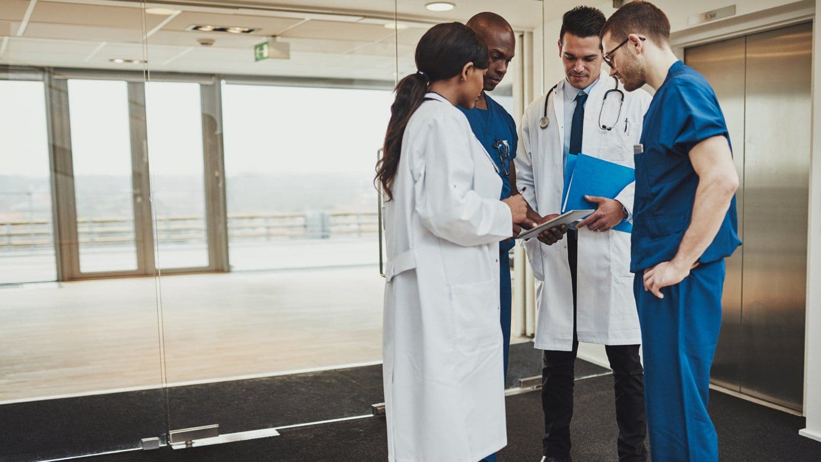 Equipe medicale echangeant autour d un dossier dans un couloir