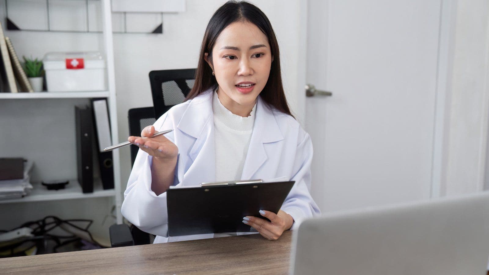 Professionnelle de sante expliquant un document a son bureau