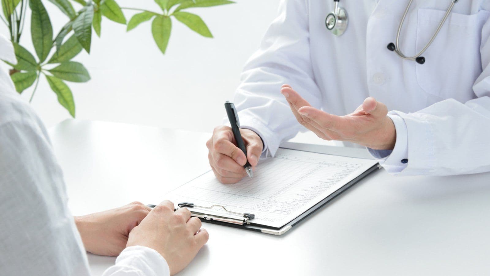Medecin remplissant un formulaire face a un patient en consultation