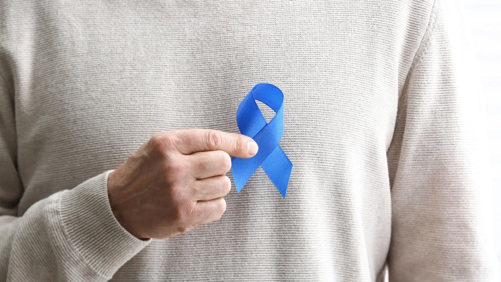 Homme tenant un ruban bleu, symbole du depistage du cancer colorectal
