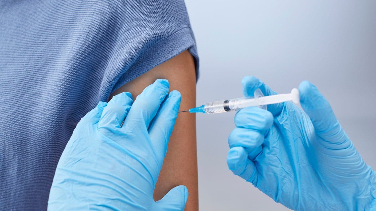 Soignant gante administrant un vaccin dans le bras d'un patient