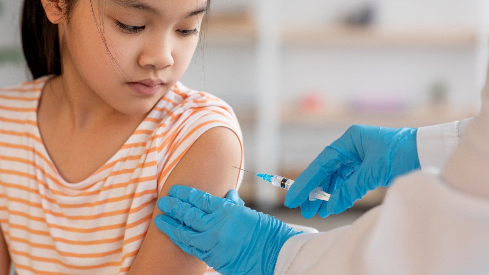 Jeune fille recevant un vaccin dans le bras chez le medecin