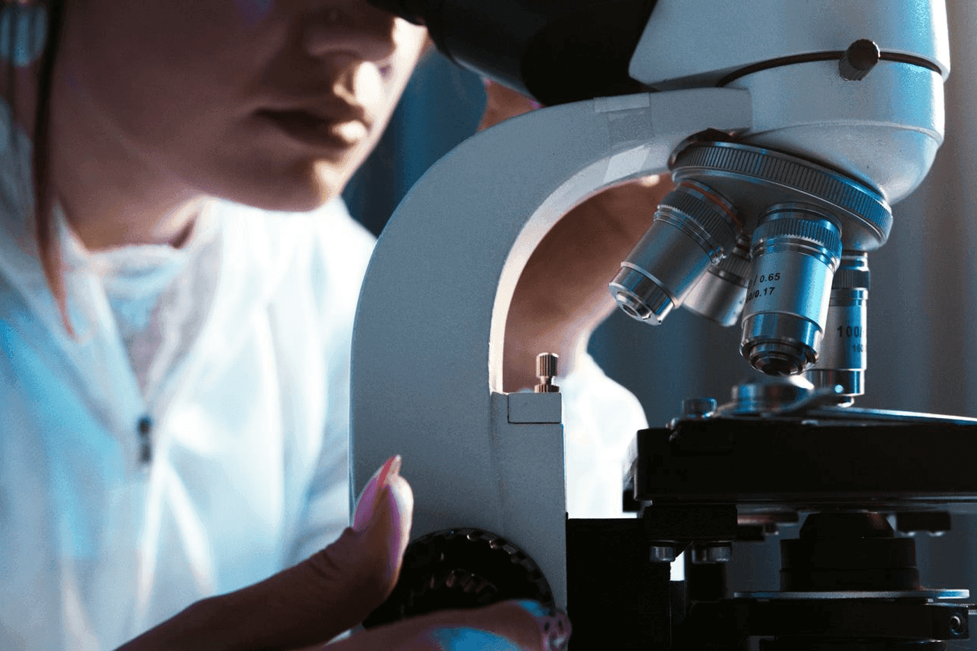 Technicienne de laboratoire observant un echantillon au microscope