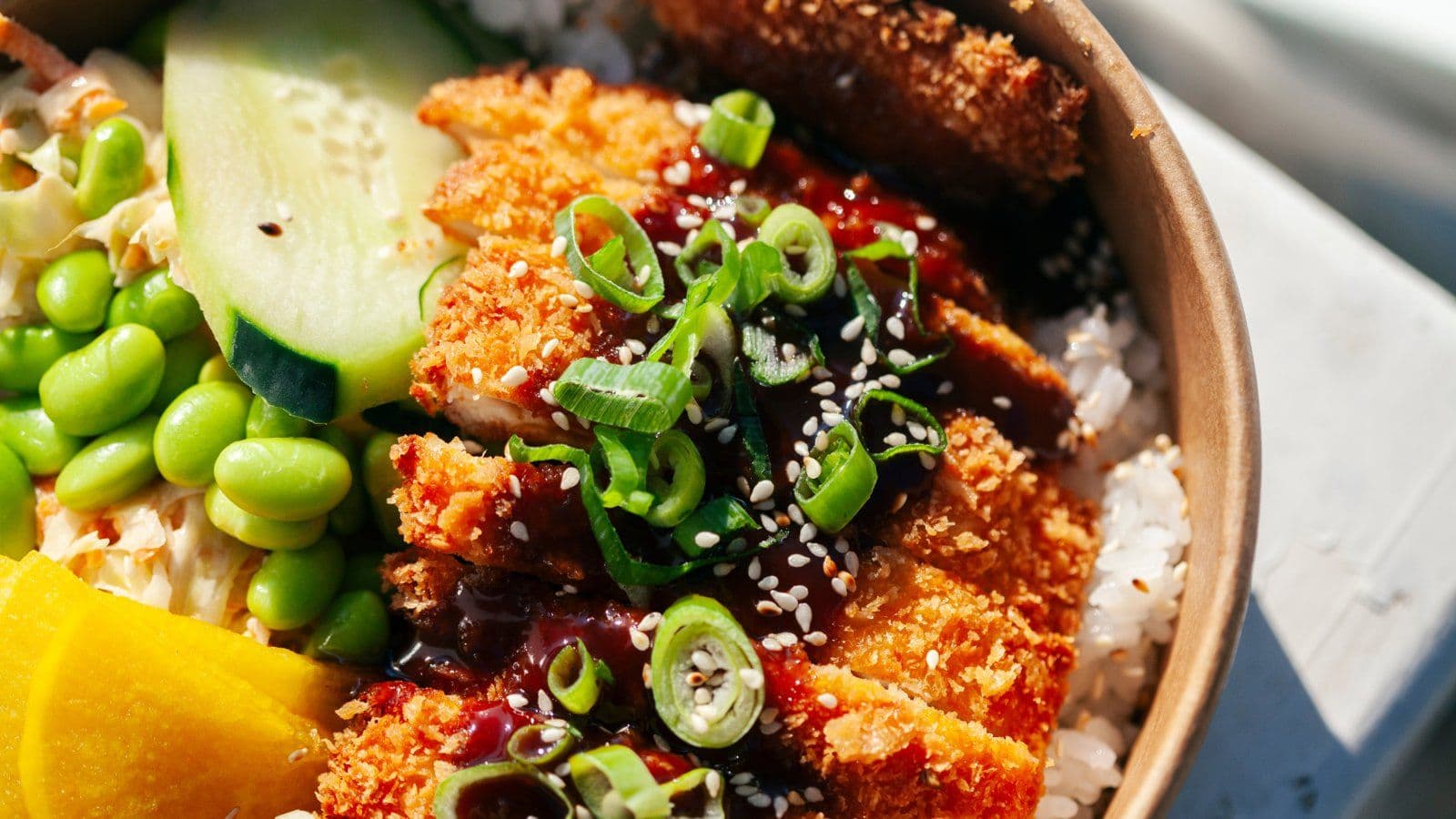 Bol repas garni de patate douce, edamame, concombre et graines