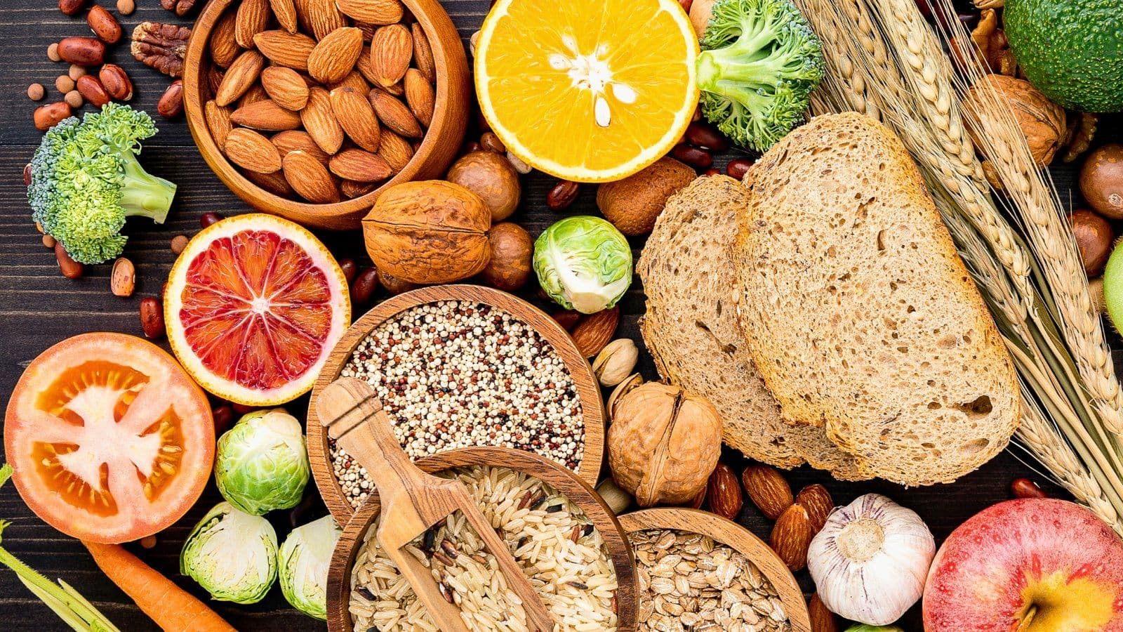 Pain complet, noix, cereales et legumes disposes sur une table