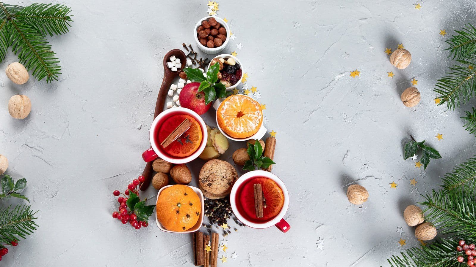 Agrumes, fruits secs et infusions epicees disposes en forme de sapin