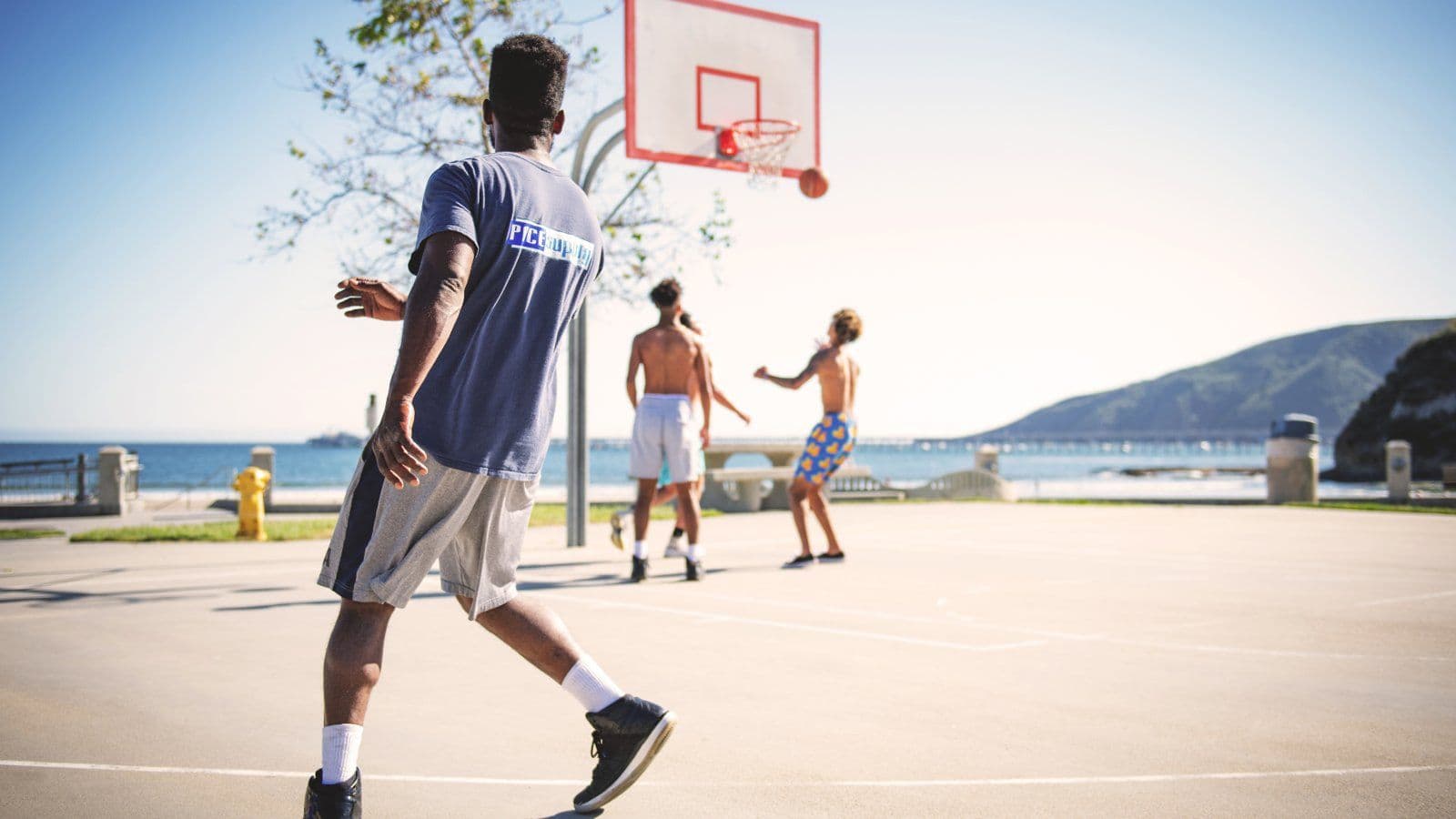 Partie de basket-ball improvisee sur un terrain en plein air
