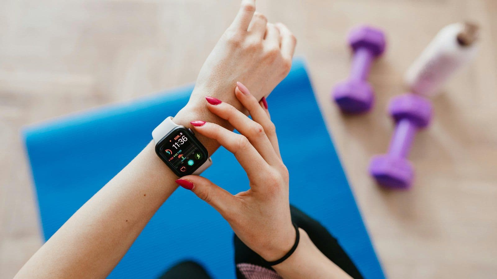 Poignet portant une montre connectee pose pres d halteres et d un tapis
