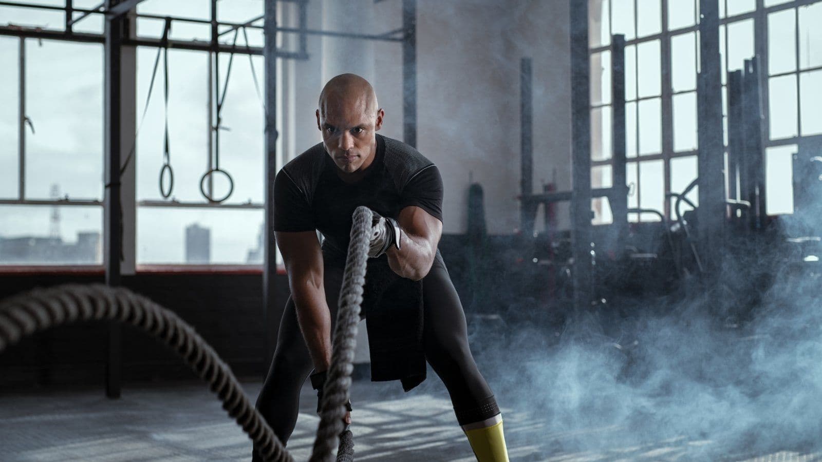 Athlete s entrainant avec des cordes ondulatoires dans un hangar