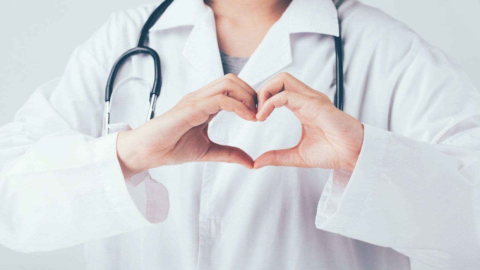 Medecin formant un coeur avec ses mains, stethoscope autour du cou