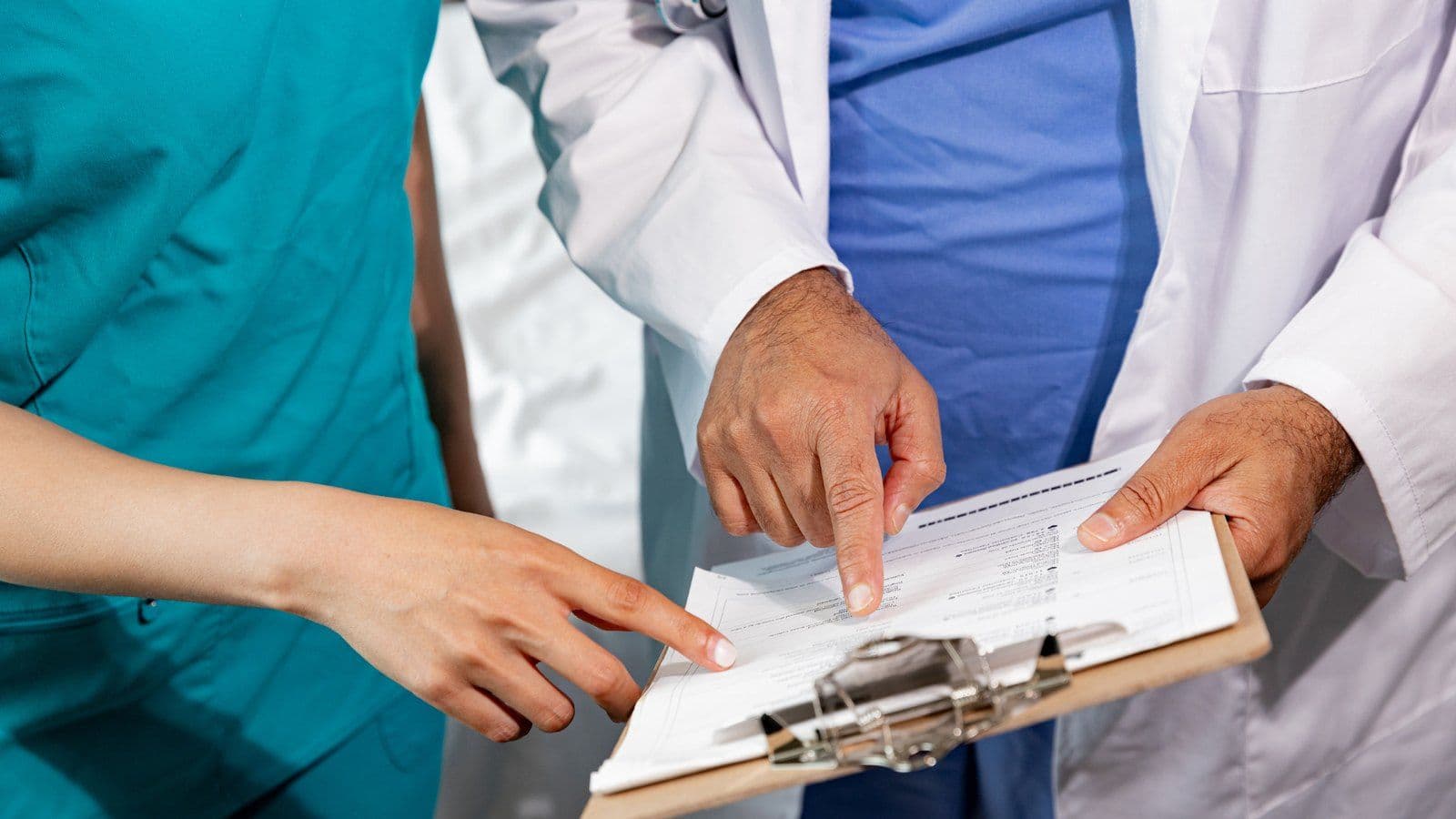 Equipe soignante examinant ensemble un dossier medical sur un porte-bloc