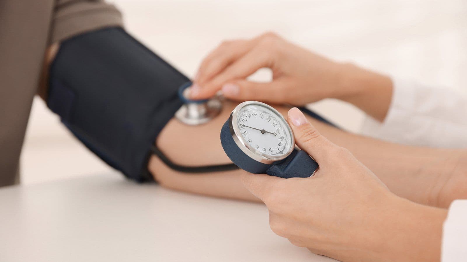 Professionnel de sante mesurant la tension arterielle d'un patient au brassard