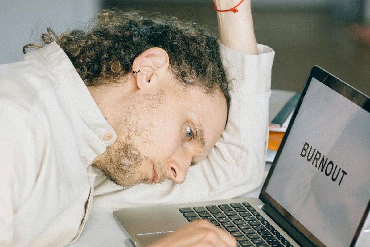 Personne épuisée à son bureau, le mot « burn-out » affiché à l'écran