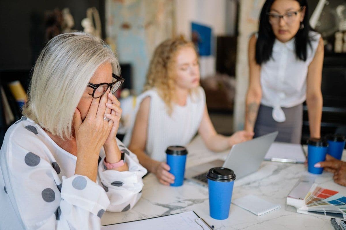 Personne se frottant les yeux en réunion, signes de fatigue au travail