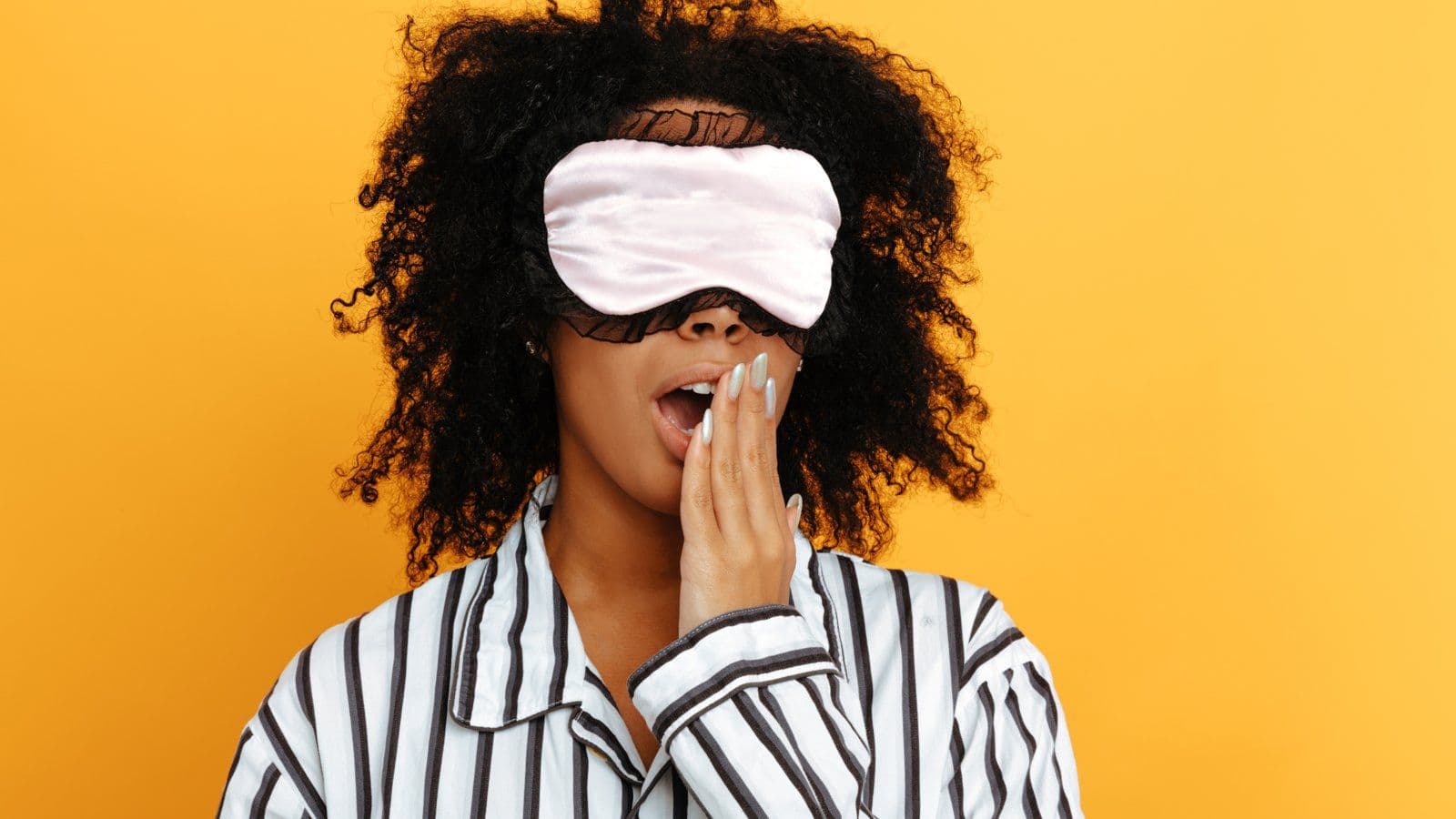 Femme baillant, masque de nuit releve sur le front, sur fond jaune