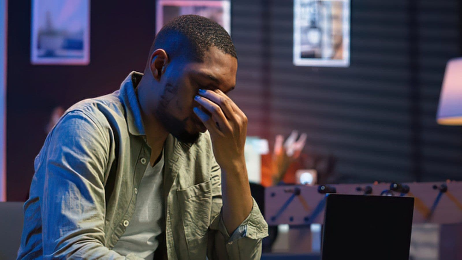 Homme se massant les yeux devant son ecran, tard le soir