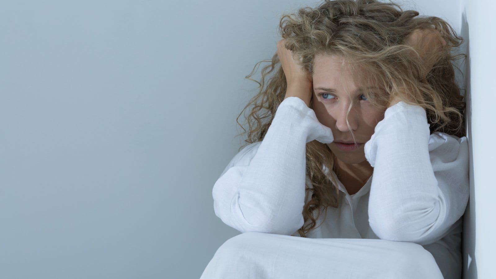 Femme les mains dans les cheveux, visage marque par l angoisse