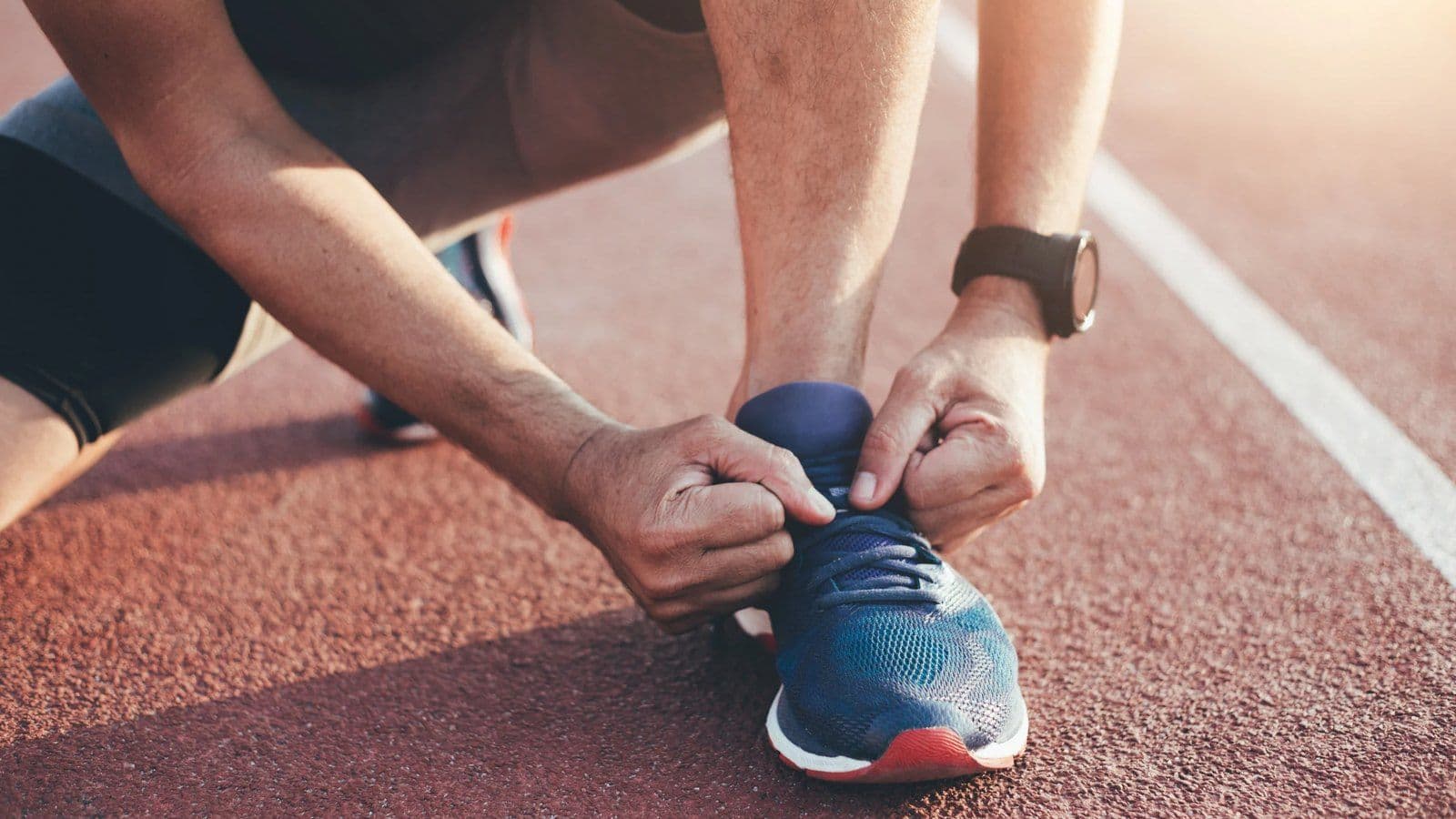 Coureur lacant sa chaussure sur une piste d athletisme